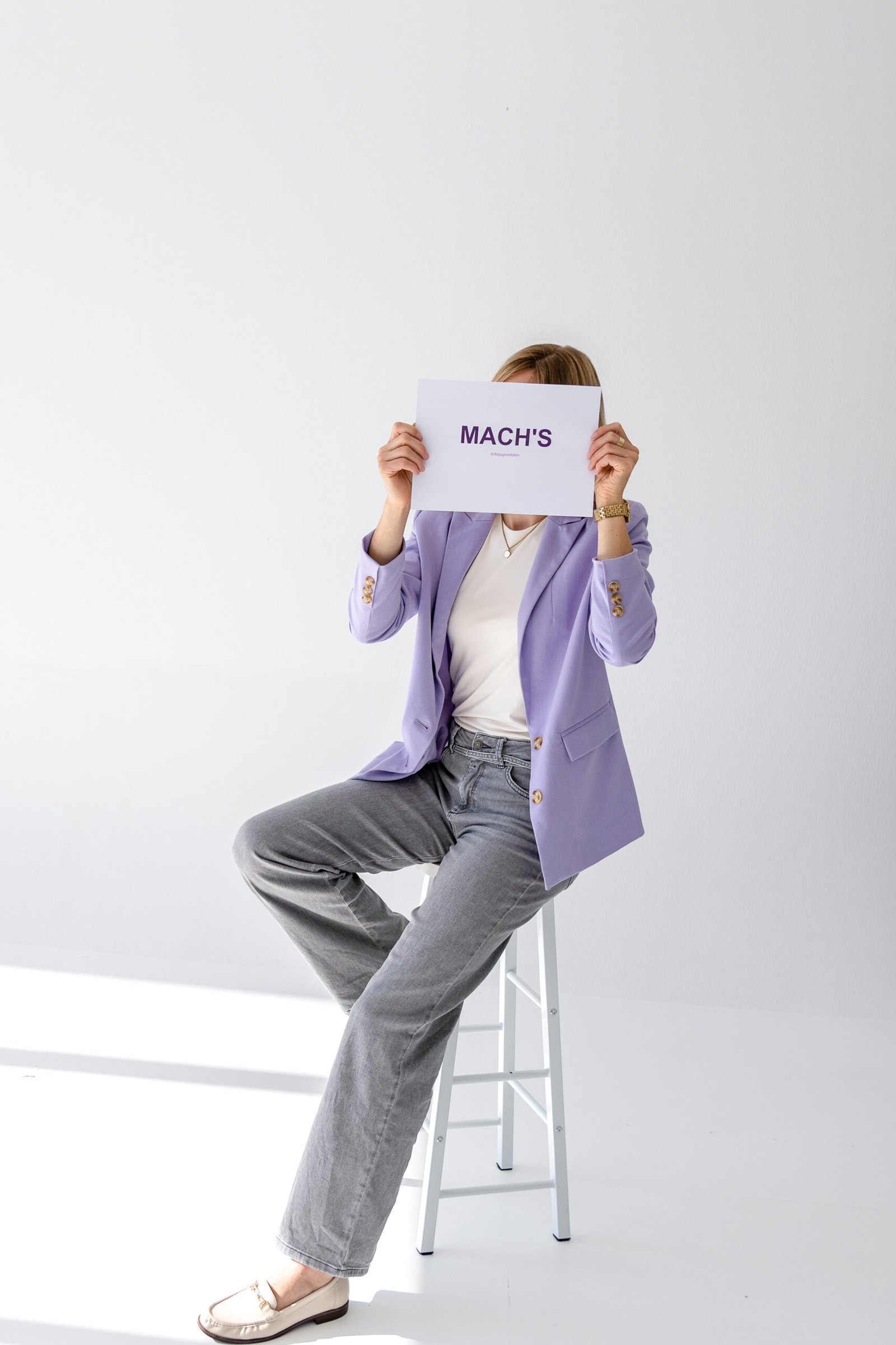 Madleen Frommholz hält ein Schild vor ihr Gesicht mit der Aufschrift „MACHS!“ als motivierender Aufruf zur Selbstständigkeit und Umsetzung des Traums vom eigenen Business